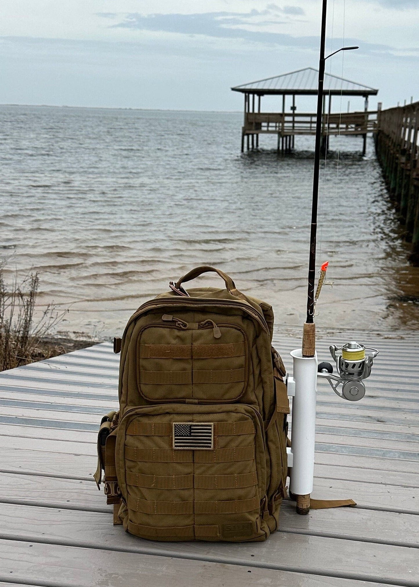 A MOLLE Rail mounted to a backpack with a fishing pole in the rod holder.